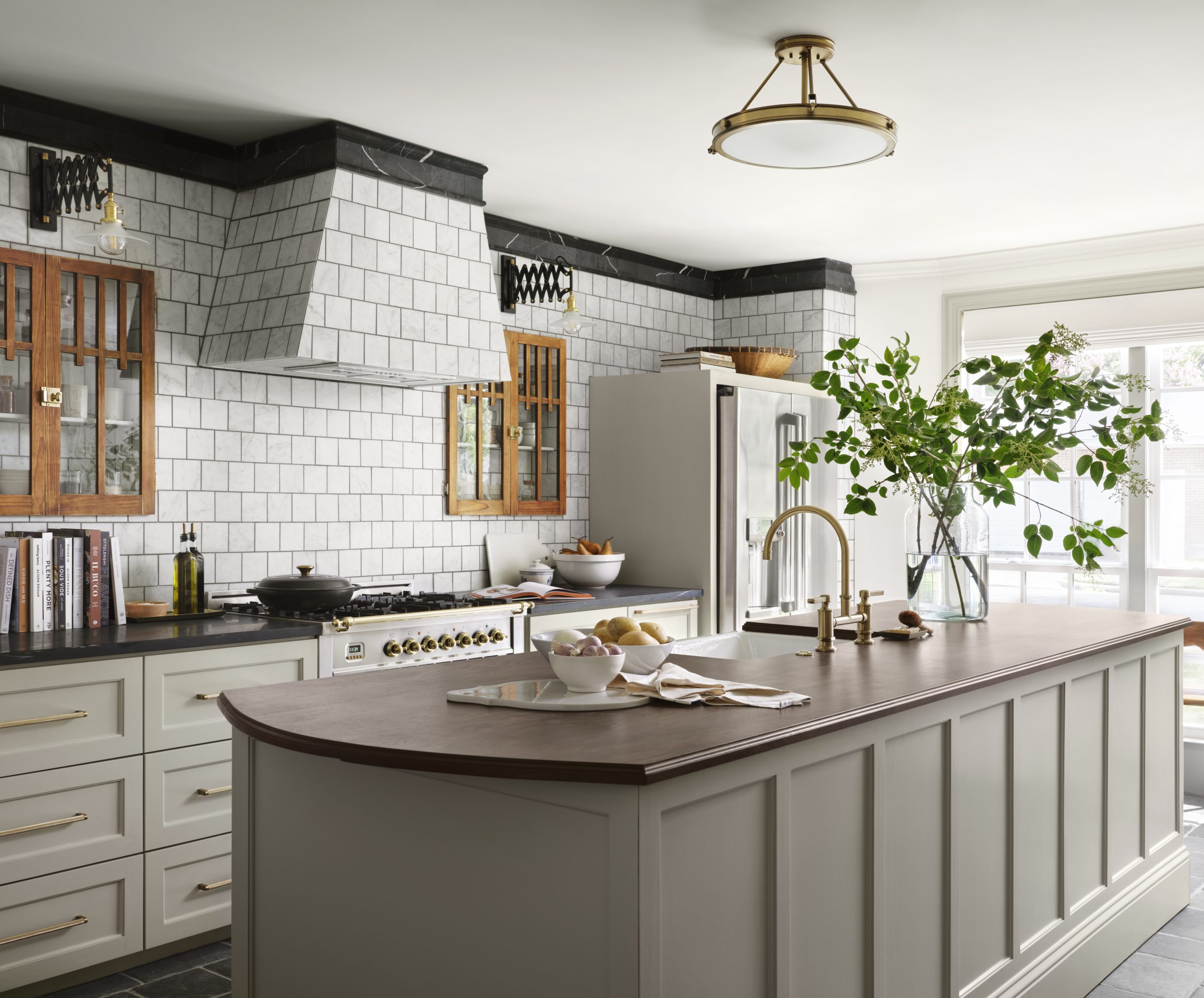 Light grey kitchen island with curved wooden countertop